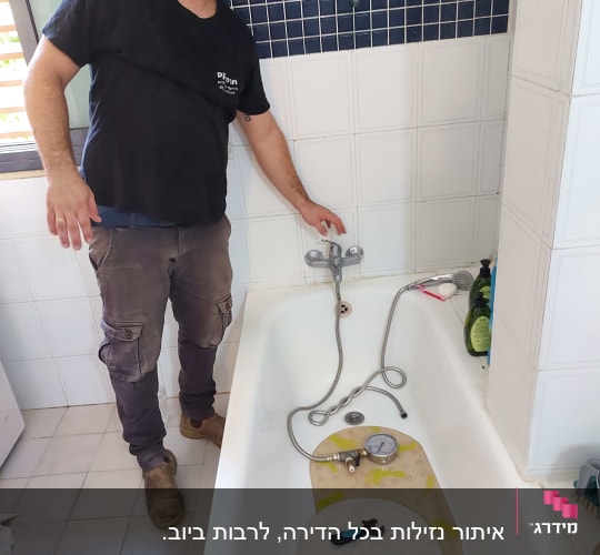 אדם בודק נזילות באמבטיה עם מד לחץ